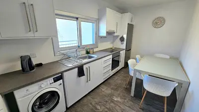 a kitchen with a sink and a washing machine at Molos city centre living in Limassol