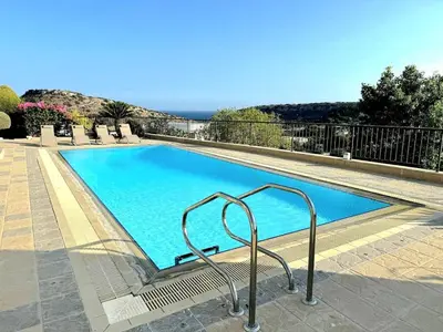 a large blue swimming pool with a metal railing at Serenity Pool & Garden Villa in Limassol