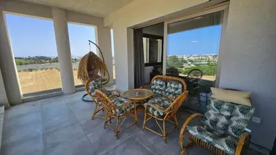 a living room with a table and chairs and windows at Suburban Escape in Limassol