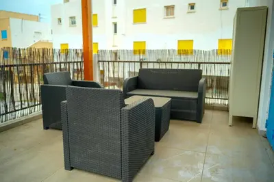 a room with two chairs and a couch on a balcony at Kapparis Avenue Beach Apartment in Paralimni