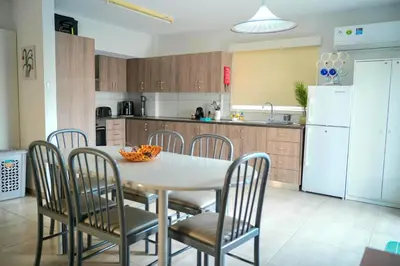 a kitchen with a table and chairs and a white refrigerator at Kapparis Avenue Beach Apartment in Paralimni