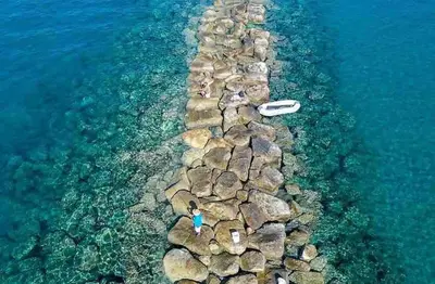a group of people laying on a rock pathway in the water at Cydonia Gardens Maisonette with shared pool in Limassol