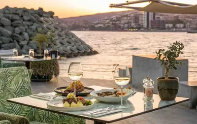 a table with plates of food and wine glasses at Cydonia Gardens Maisonette with shared pool in Limassol