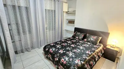 a bedroom with a bed with a floral comforter at Dasoudi beach apartment in Limassol