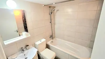 a bathroom with a toilet and a sink and a tub at Dasoudi beach apartment in Limassol