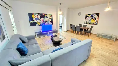 a living room with a blue couch and a table at Dasoudi beach apartment in Limassol