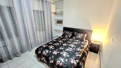 a bedroom with a bed with a floral comforter at Dasoudi beach apartment in Limassol
