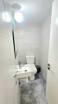 a bathroom with a white toilet and a sink at Dasoudi beach apartment in Limassol