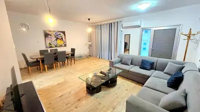 a living room with a couch and a dining room at Dasoudi beach apartment in Limassol