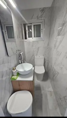 a white bathroom with a sink and a toilet at Sea Breeze 3 Bed Frontline Flat in Limassol