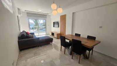 a living room with a table and a couch at Sea Breeze 3 Bed Frontline Flat in Limassol