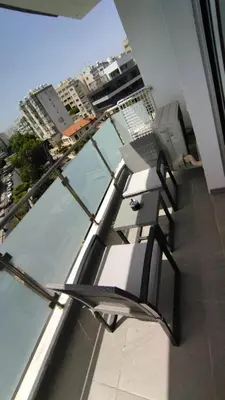 a bench on a balcony with a view of a city at The Suave - Limassol City Centre Luxury in Limassol