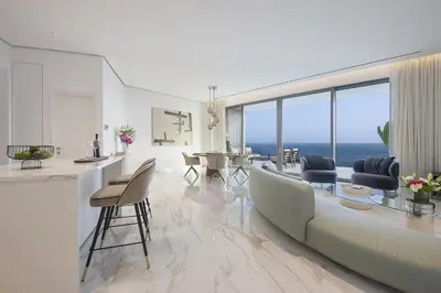 a living room with a couch and a table with chairs at Trilogy Limassol Seafront in Limassol