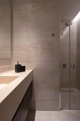 a bathroom with a glass shower and a sink at Trilogy Limassol Seafront in Limassol