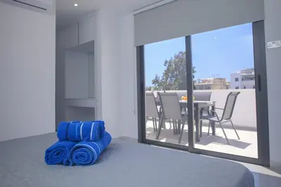 a bedroom with a bed and a table with chairs at Elegant penthouse in City Centre in Larnaka