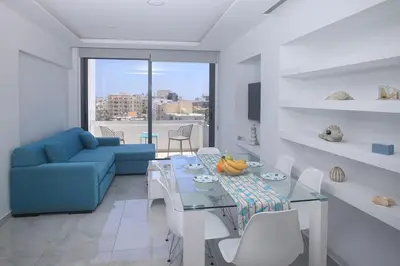 a living room with a table and a blue couch at Elegant penthouse in City Centre in Larnaka