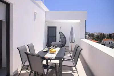 a dining room with a table and chairs on a balcony at Elegant penthouse in City Centre in Larnaka