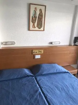 a bedroom with a blue bed and a picture on the wall at Cornelia Hotel Ayia Napa Center in Ayia Napa