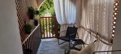 a balcony with two chairs and a door with curtains at Paradise Garden Sweet Studio in Limassol