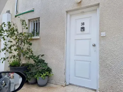 a white door with the number next to a building at Paradise Garden Sweet Studio in Limassol