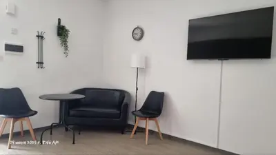 a room with two chairs and a table and a television at Paradise Garden Sweet Studio in Limassol