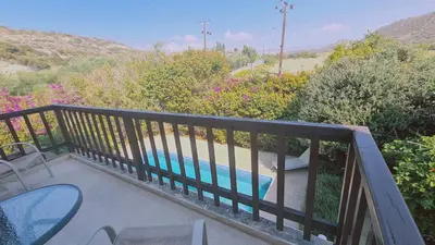 a balcony with a view of a swimming pool at STAY Villa Michalis in Pissouri