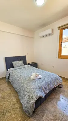 a bedroom with a bed with a towel on it at Central City Rooms in Larnaka