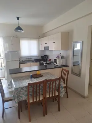 a kitchen with a table and two chairs and a table and a table and chairs at Easy 2 bedroom apartment, Makenzi beach in Larnaka