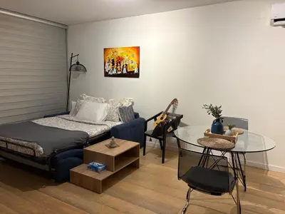 a living room with a bed and a glass table at Stylish Apt near UNIC Medical School & EUC in Engomi