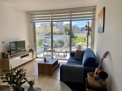 a living room with a blue couch and a television at Stylish Apt near UNIC Medical School & EUC in Engomi