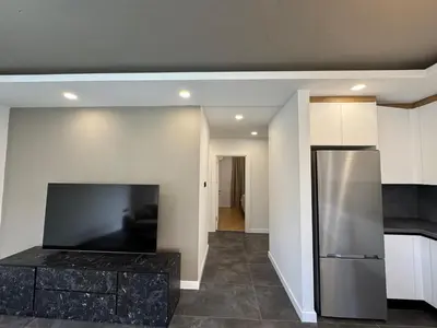 a kitchen with a refrigerator and a living room at Kervansaray Comfort in Ayii Trimithias