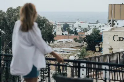 a woman standing on a balcony looking at the ocean at One Love One World Ayia Napa Square Hostel in Ayia Napa