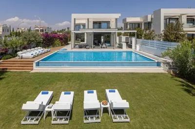 a villa with a swimming pool and lounge chairs at Villa JoJo Seafront in Ayia Napa