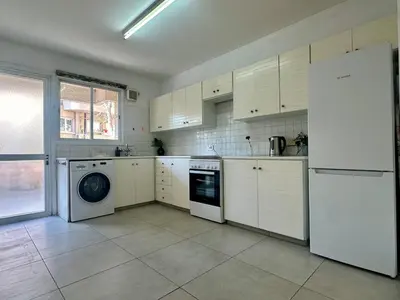 a kitchen with white cabinets and a washer and dryer at 2 bedrooms flat near center in Engomi