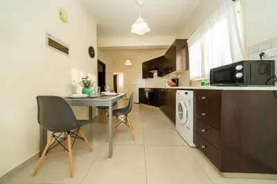 a kitchen with a table and chairs and a microwave at 2 bedroom flat in Nicosia
