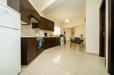 a kitchen with brown cabinets and a table in it at 2 bedroom flat in Nicosia