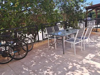 a table and chairs on a balcony with trees at ANDRIA'S luxury family studio near Casino limassol in Limassol