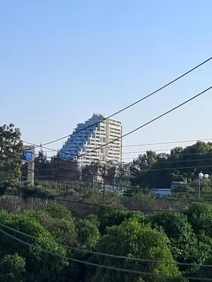 a tall building in the distance with trees and power lines at ANDRIA'S luxury family studio near Casino limassol in Limassol