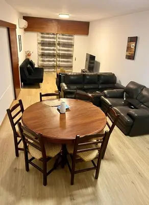 a living room with a table and a leather couch at Tiffany 11 Finikoudes in Larnaka