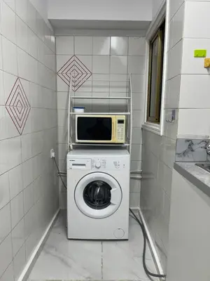 a laundry room with a microwave and a washing machine at Tiffany 11 Finikoudes in Larnaka