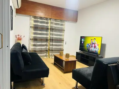 a living room with a couch and a flat screen tv at Tiffany 11 Finikoudes in Larnaka