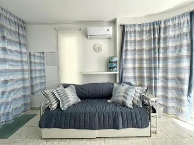 a blue couch in a living room with windows at STAY ALKYONI Villa in Protaras