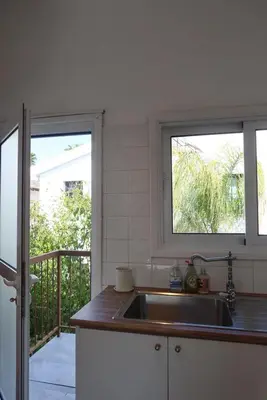 a kitchen with a sink and two windows at Cozy Holiday Apartment with Balcony in Pyla