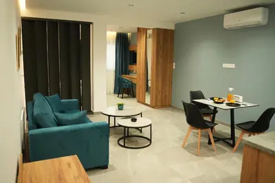 a living room with a blue couch and a table at Zen City Suites in Larnaka