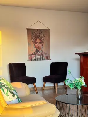 a living room with two chairs and a painting on the wall at Gold Feather 2Bedroom Center Location and Pool in Ayia Napa