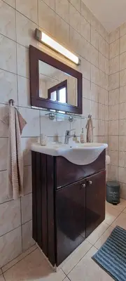 a bathroom with a sink and a mirror at The Cozy Home Stay in Larnaca in Larnaka