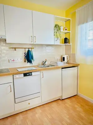 a kitchen with white cabinets and a sink at Sunny Days Apartment in Paralimni