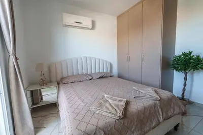 a bedroom with a bed and a plant on a table at Mythical Sands Resort and Spa in Paralimni