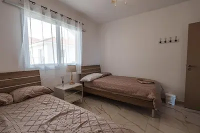a bedroom with two beds and a window at Mythical Sands Resort and Spa in Paralimni