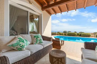 a living room with a couch and a pool at Villa Thea, Luxury Cliff Sea View in Pissouri